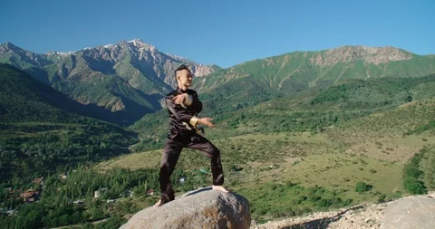 Slow motion footage of a man practicing martial arts. Bright emotions on his Video stock 115881323