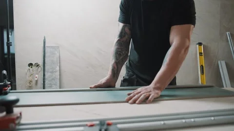 Slow motion footage of a man working on tile cutting in a workshop Stock Footage 307039617