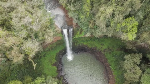 Slow motion footage over a waterfall among trees. Aerial. Video stock 332259766