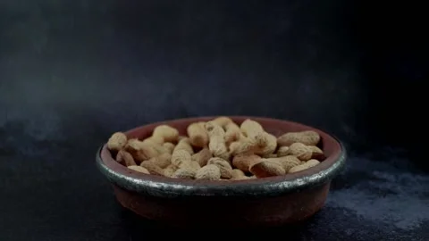 Slow motion footage of peanuts in the shells in a rustic bowl  Stock Footage 150127473