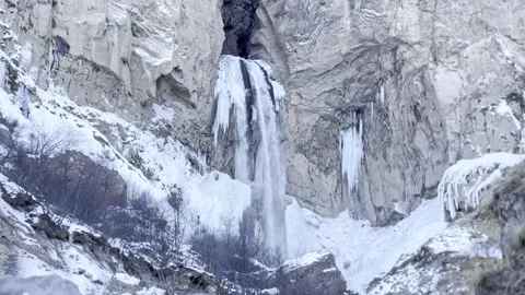 Slow motion footage snow-covered winter rocks and mountain waterfall, nature  Stock Footage 288101632