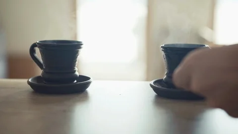 Slow motion footage two cups of coffee sitting on table steaming Stockbeeldmateriaal 109161530