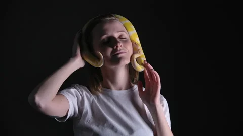 Slow motion footage of woman with python albino crawling on her head Stock Footage 144043703