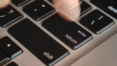 Slow motion of forefinger pressing enter key on modern laptop Stockbeeldmateriaal 291854275