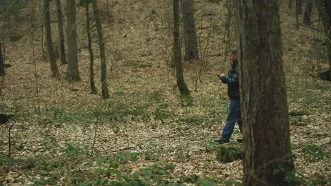 Slow motion in the forest man uses smarphone walk smile feel happy technology Stock Footage 127168519