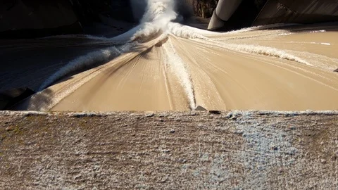 Slow motion forward moving over water flowing over concrete spillway Stock Footage 120921914