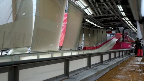 Slow motion of four bobsledders riding their red color bobsleigh in a Stock Footage 98257812