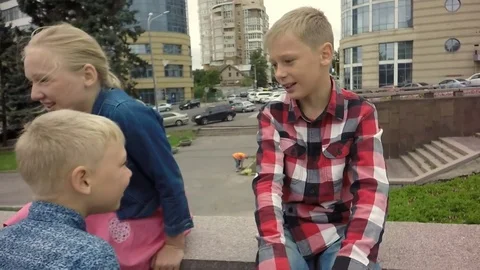 Slow motion. The four children are talking happily. Stockbeeldmateriaal 79584670