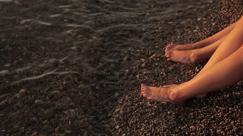 SLOW MOTION: Four womans legs on beach in sea waves Stock Footage 140142737