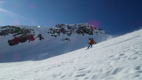 Slow motion of freeride snowboarder spraying snow around while riding down slope Stock Footage 121597960