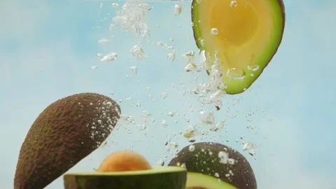 Slow Motion of fresh avocado falling into water splash on colorful blue backgrou Vídeo Stock 162826287