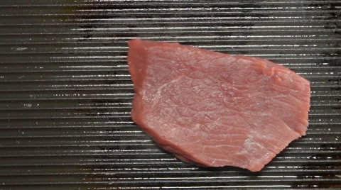SLOW MOTION: Fresh beef steak falls on a grill (top view) Stock Footage 68489741