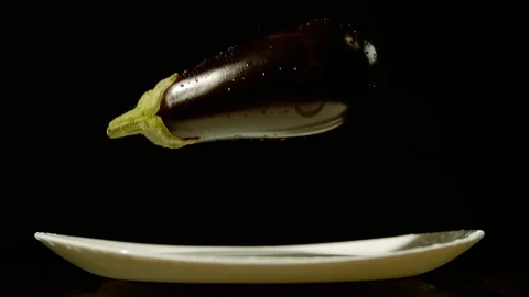 Slow motion fresh  eggplant falling from the spray of water Stock Footage 125256805