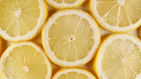 Slow Motion of Fresh Lemons Slices on Yellow Background. Lemons Fruit Pattern Stock Footage 162808434