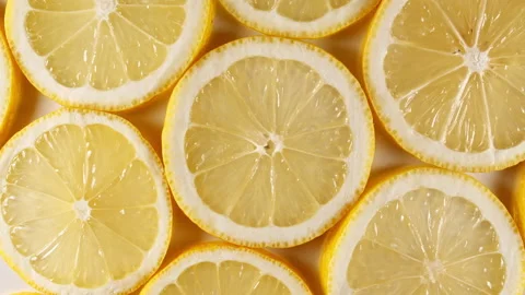 Slow Motion of Fresh Lemons Slices on Yellow Background. Lemons Fruit Pattern Stock Footage 162808988