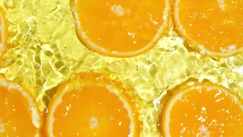 Slow motion of fresh orange slices under rippling water with bubbles Stock Footage 338397449