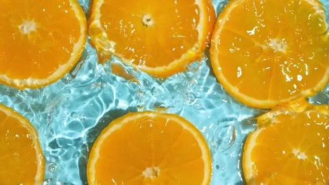 Slow motion of fresh orange slices under rippling water with bubbles. Stock Footage 339620732