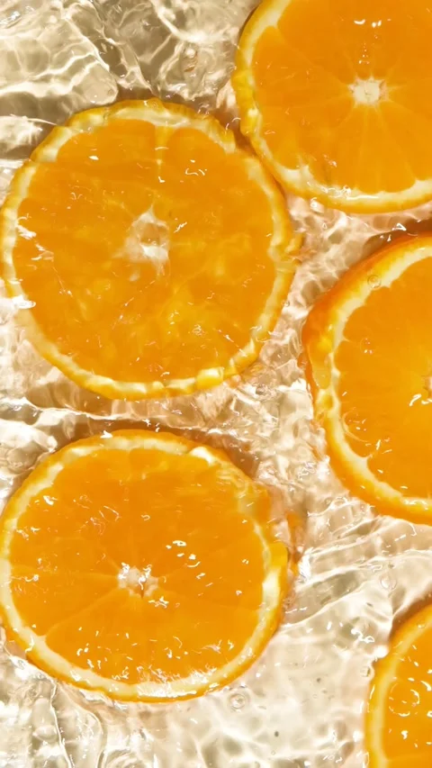Slow motion of fresh orange slices under rippling water with bubbles Stock Footage 340550283
