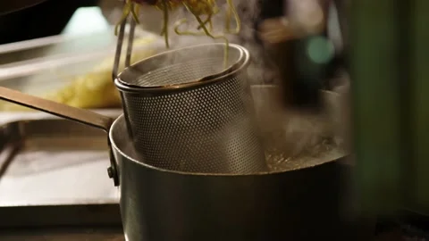 Slow motion fresh pasta put into water in restaurant kitchen, 4K Stock Footage 229808946