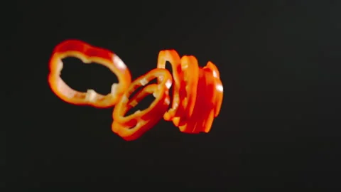 SLOW MOTION:  Fresh Red Bell Pepper Slices Falling Down On A Black Surface 動画素材 161688065