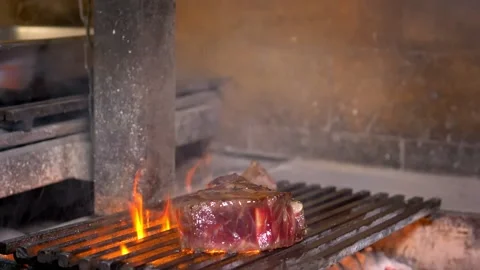 Slow motion. Fried tomahawk steak is sprinkled with oil to make a fire. Stock Footage 154888452