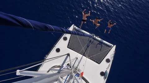 Slow motion of friends jumping from sailing catamaran in the sea water Stock Footage 130143782
