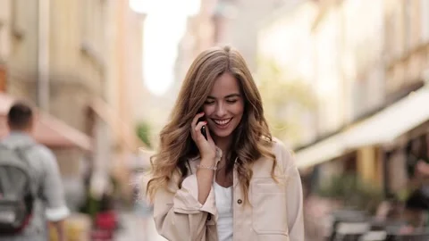 Slow motion front view of a young beautiful blonde woman walking and calling on Stock Footage 144567805