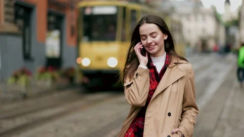 Slow motion front view of a young beautiful woman walking and calling on phone Stock Footage 144569319