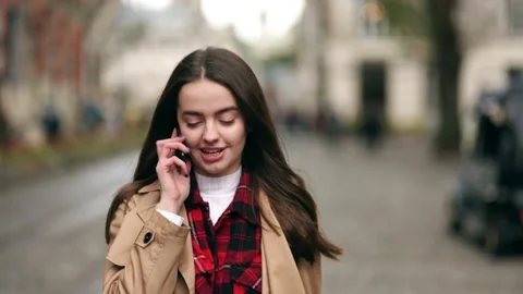 Slow motion front view of a young beautiful woman walking and calling on phone Stock Footage 144574719