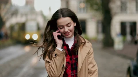 Slow motion front view of a young beautiful woman walking and calling on phone Stock Footage 144996710