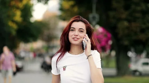 Slow motion front view of a young beautiful woman in a white t-shirt walking and Stock Footage 222947761