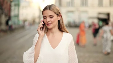 Slow motion front view of a young beautiful blonde woman in a white dress Stock Footage 235943385