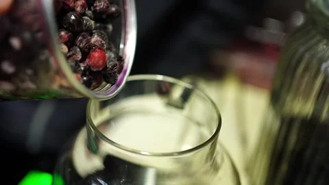 Slow motion frozen berries falling into glass teapot Stock Footage 311667516
