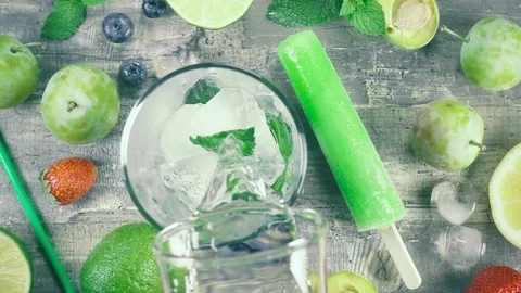 Slow motion fruit drink with ice top view Video stock 93200319