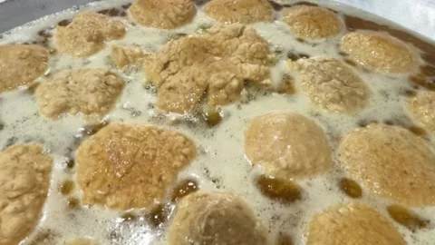 Slow motion frying meatballs in boiling cooking oil using a frying pan Stock Footage 320978113