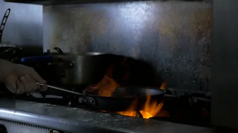 Slow motion frying pan with flames in commercial kitchen Stock Footage 64228185