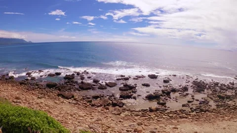 Slow motion full horizontal still view look out to blue ocean horizon at rocky s Stock Footage 313345616