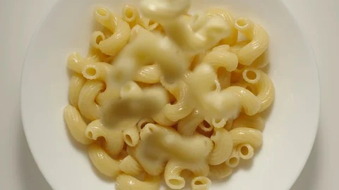 SLOW MOTION: Fusilli pasta falling into a white plate - Top View Stock Footage 100631819