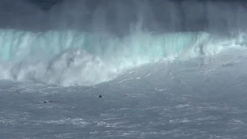 Slow motion, Giant ocean wave crashes onto surfers in the water, extreme sport Stock Footage 77611108