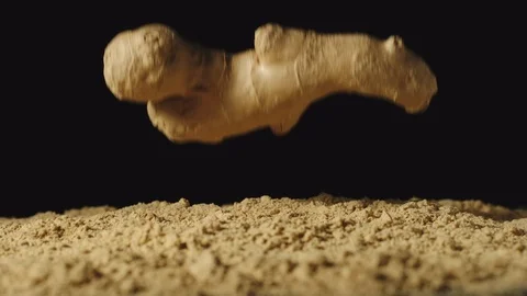 SLOW MOTION: Ginger root falls in powder and powder scatters around Stock-Footage 107501311