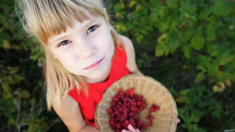 Slow motion girl eats ripe red juicy raspberry in the garden Stock Footage 115515524