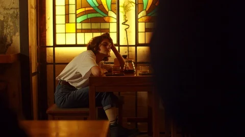 Slow motion, girl sit at a table in a cafe,wait for someone and drink tea Stock Footage 121935796