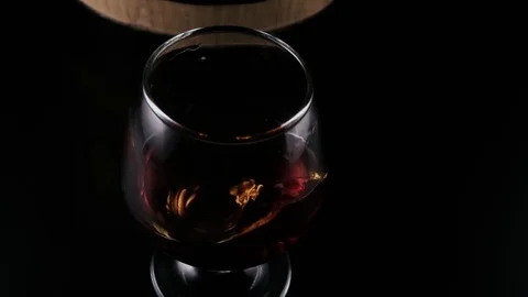 Slow motion. A glass of brandy rolls out on the table Stock-Footage 75447197