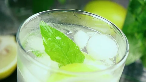 Slow motion in a glass with ice mint and lemon juice Stock-Footage 92207234