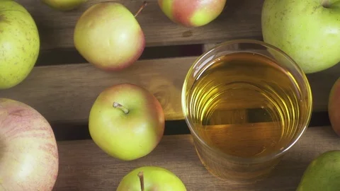 Slow motion a glass of juice on a table among apples top view Stock Footage 88142996