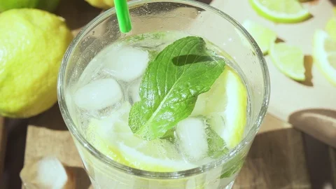 Slow motion in a glass with lemonade put a cocktail straw Stock Footage 89087041
