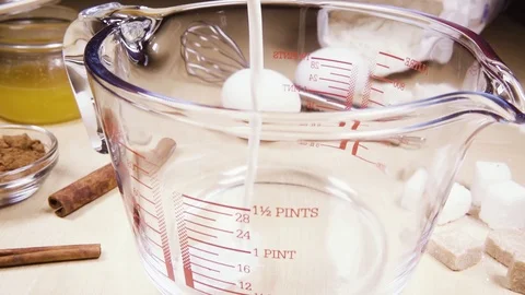 Slow motion glass measuring cup on the table near the ingredients Stock Footage 95640128