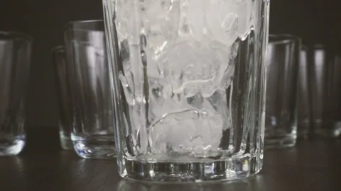 Slow motion in a glass on a table with ice pour water Stock Footage 87698861