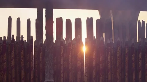 Slow motion of glowing incense sticks aligned in temple interior at sunset Stock Footage 313950433