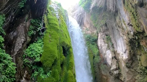 Slow motion going from top to bottom of a waterfall between rock walls and wi Video stock 194820108
